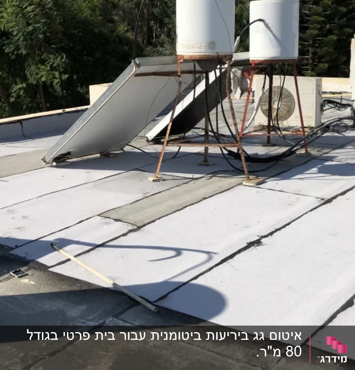 גג עם יריעות איטום לבנות ומיכלי מים
